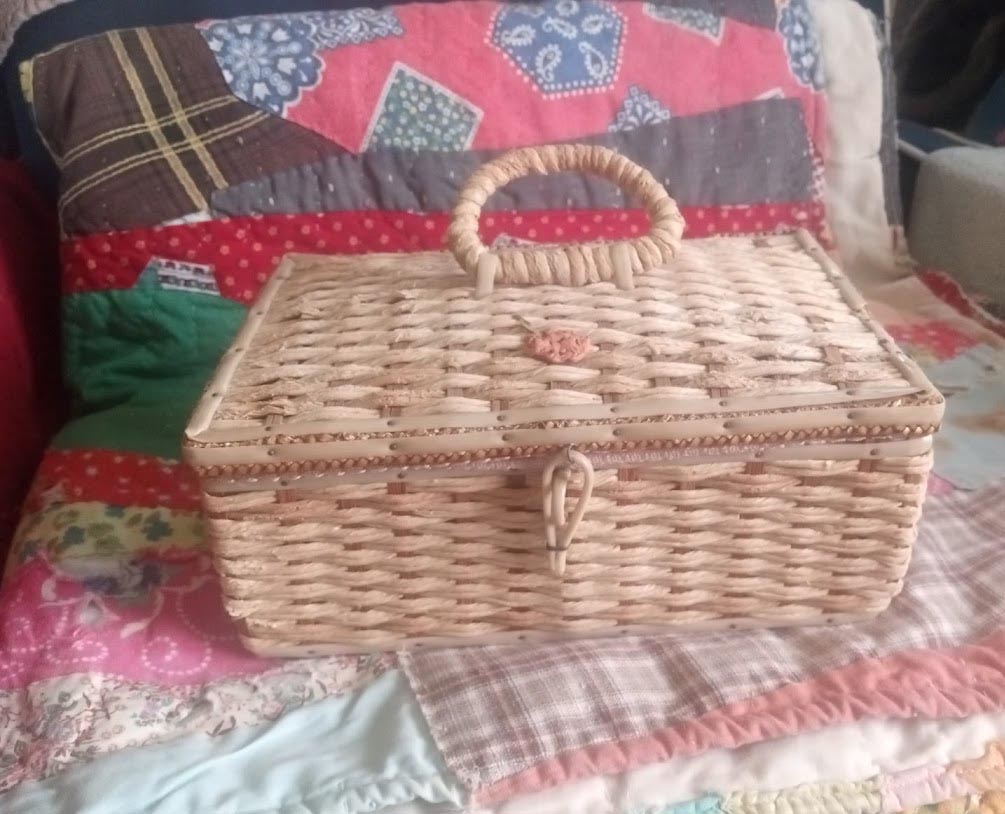 Aunt Annie's closed sewing basket on quilt