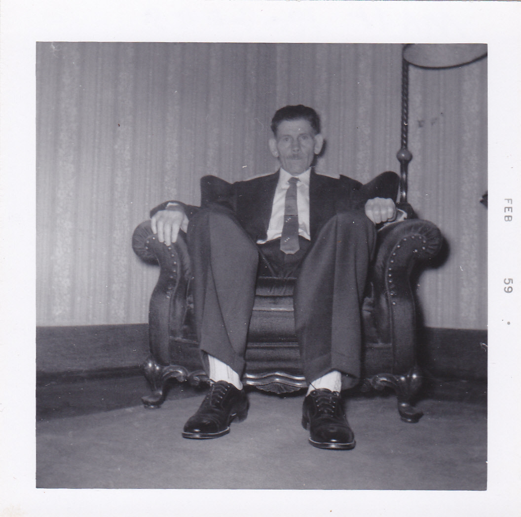 Matt Rogers in suit seated in chair