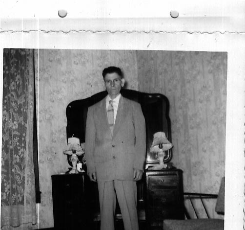 Matt Rogers standing by dresser and lamp