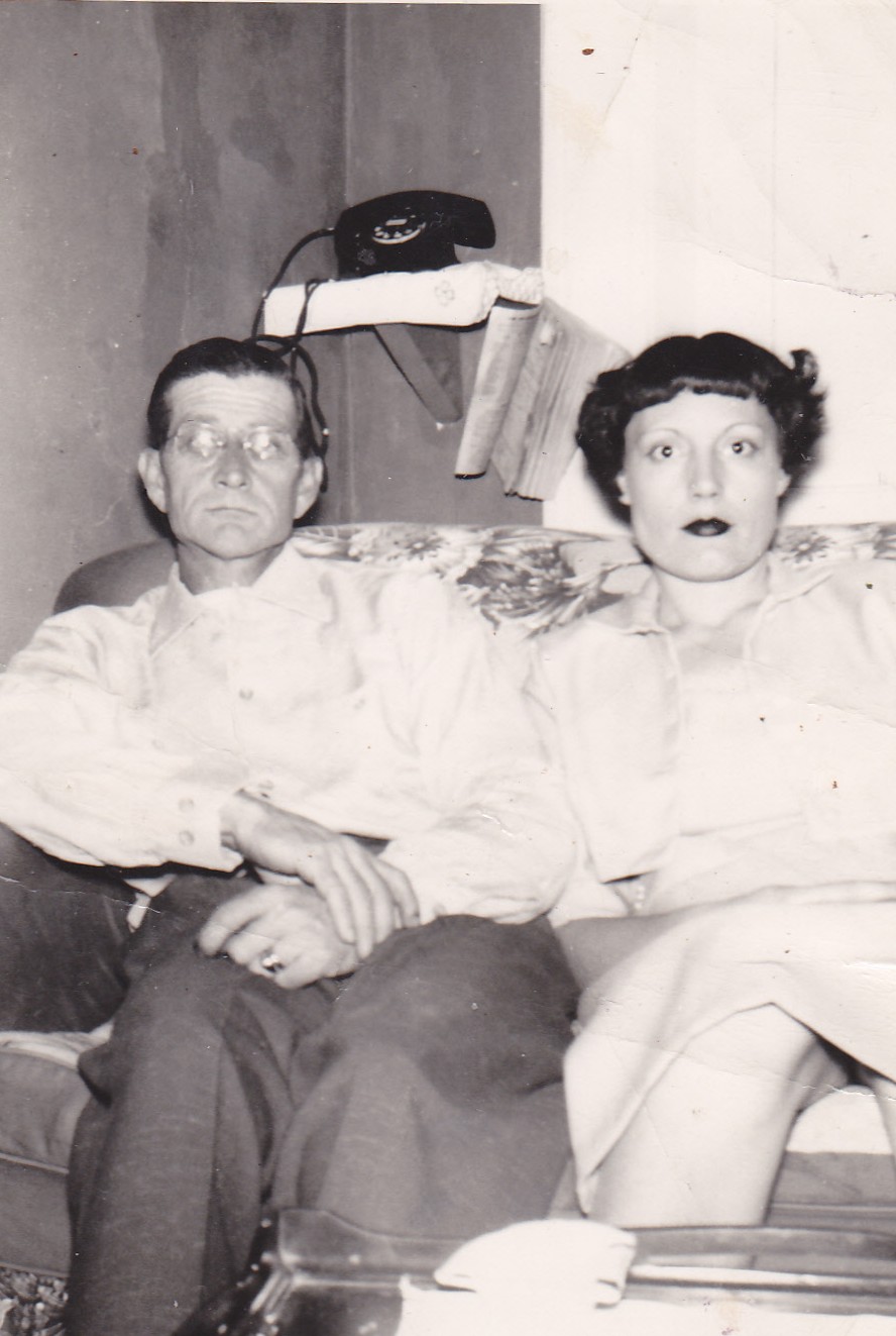 Elmer and Mary Doan sitting on the couch beneath a rotary phone