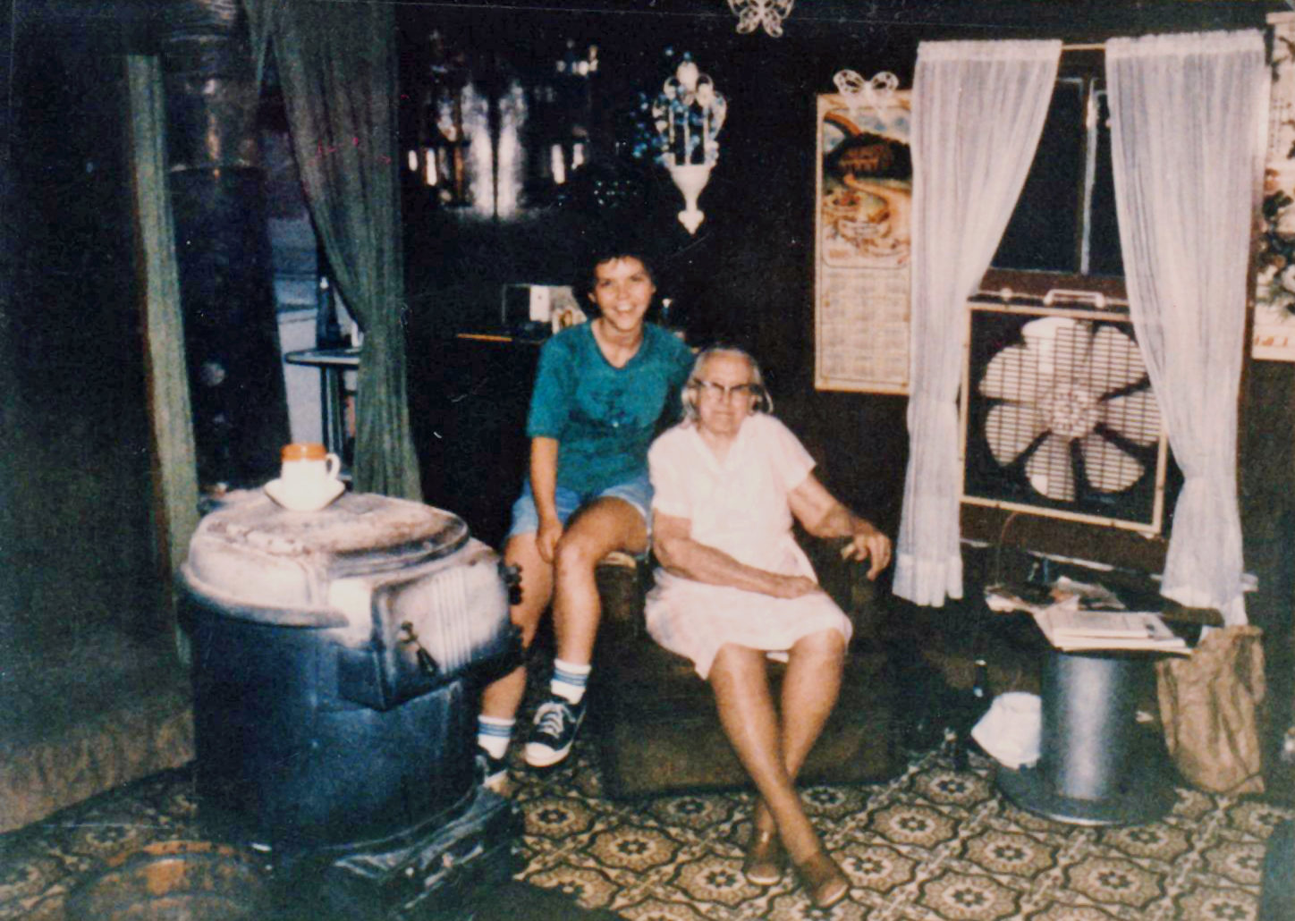 Janda Holder & Hazel Rogers sitting by potbelly stove